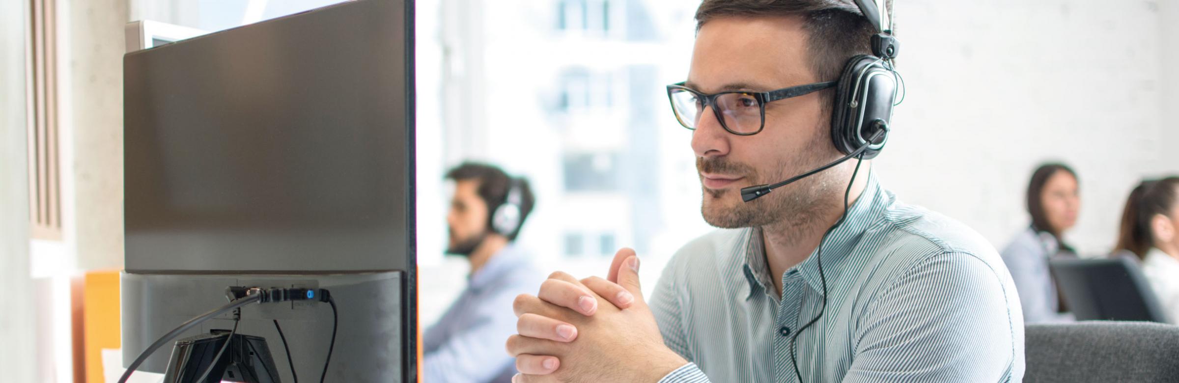 Un technicien HelpDesk aide un client au téléphone