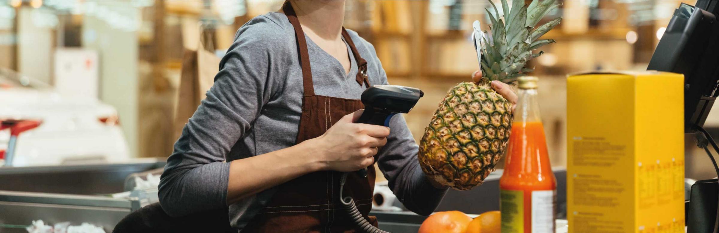 Une hôtesse de caisse scanne des produits